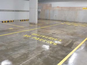 Car park with wheel stops and concrete sealing.