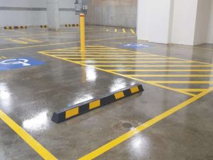Car park with wheelstops, bollards, height safety bars, bike racks and concrete sealing.